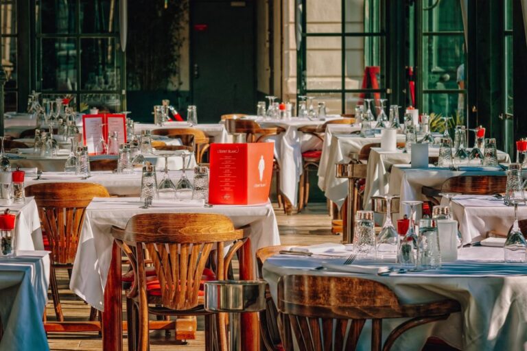 A restaurant with many tables and chairs set up for dinner.
