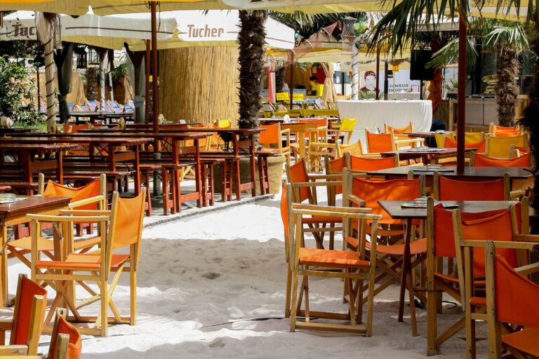 A restaurant with orange chairs and tables in the middle of it.