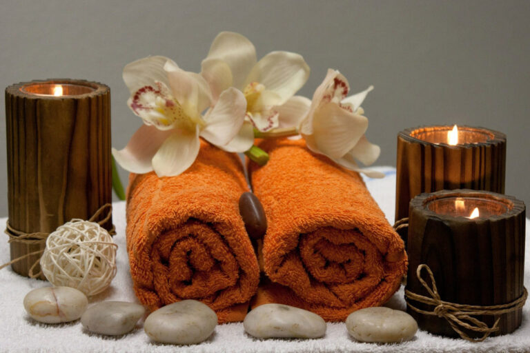 A towel with two rolled up towels and flowers on it.