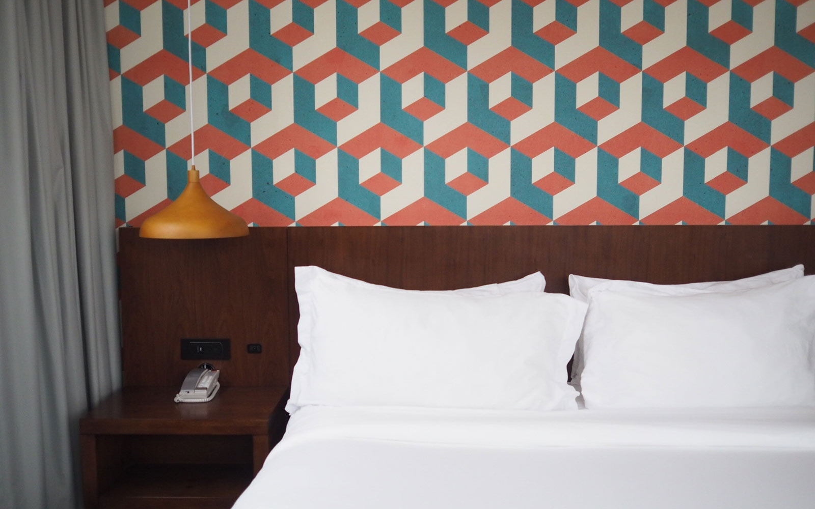 A bed room with a white bedspread and a lamp