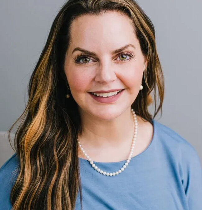 A woman with long hair wearing a blue shirt.