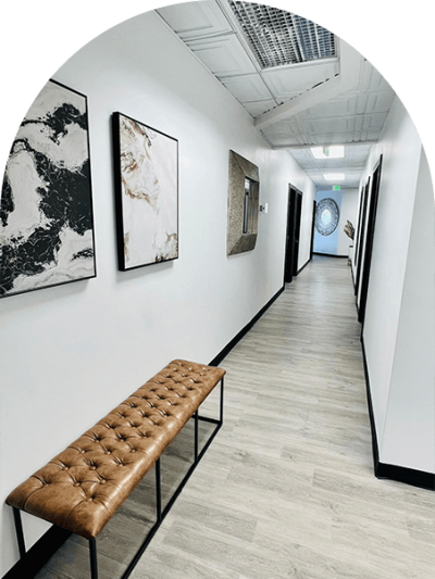 A long hallway with benches and pictures on the wall.