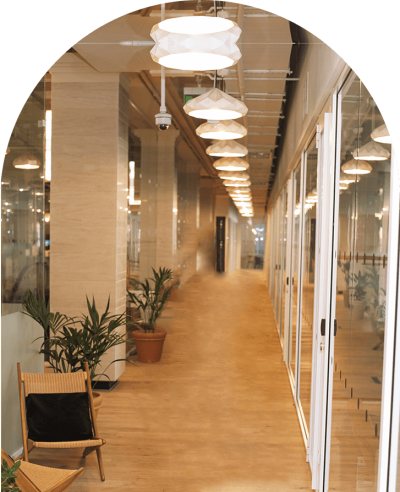 A hallway with many glass doors and plants.