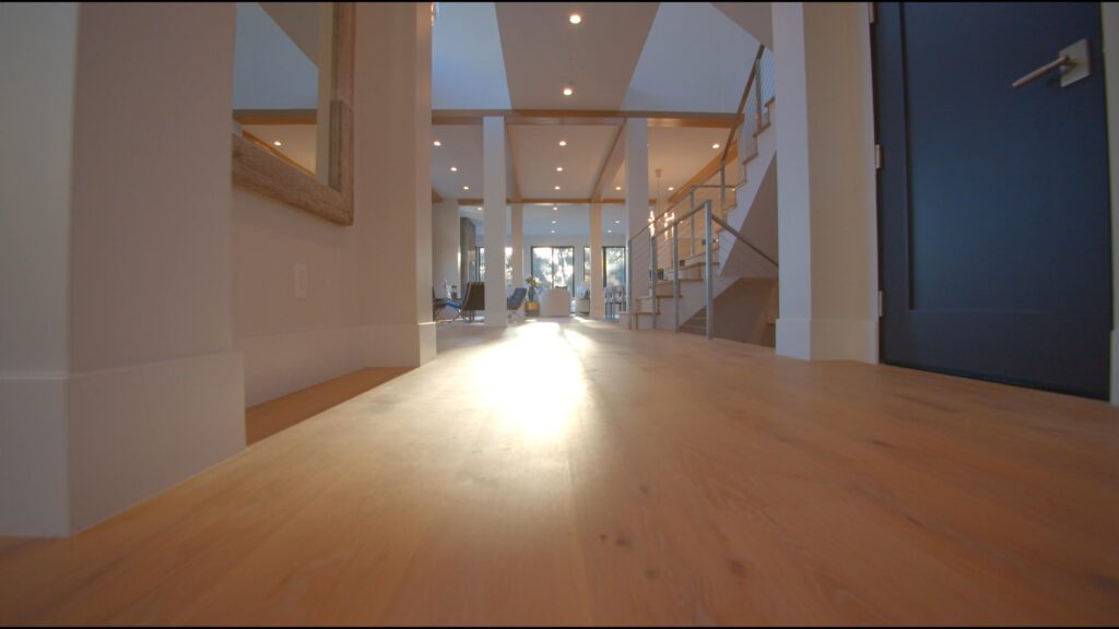 A large room with hard wood floors and white walls.
